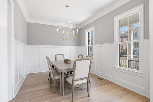 7018 Southvale Blvd, Franklin, TN 37064 - dining room featuring a decorative wall, a chandelier, wainscoting, and light wood-style flooring