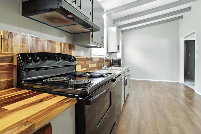 5011 Jarrett Rd, Chattanooga, TN 37416 - kitchen featuring black range with electric stovetop, under cabinet range hood, tasteful backsplash, light wood finished floors, and butcher block counters