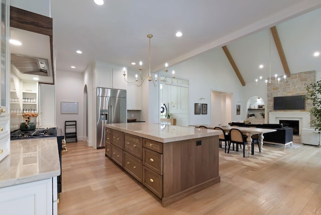 1744 Blackburn Ln, Spring Hill, TN 37174 - kitchen featuring stainless steel appliances, white cabinets, light wood-style flooring, beamed ceiling, and a fireplace