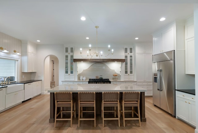 1744 Blackburn Ln, Spring Hill, TN 37174 - kitchen featuring stainless steel built in fridge, dishwasher, decorative backsplash, arched walkways, and light wood-style floors