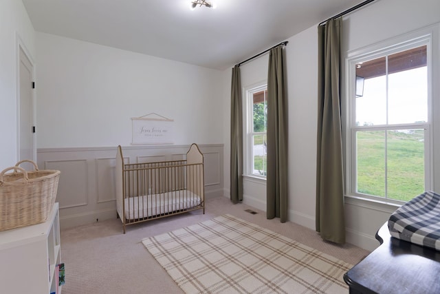 1744 Blackburn Ln, Spring Hill, TN 37174 - bedroom with light carpet, wainscoting, a crib, and a decorative wall