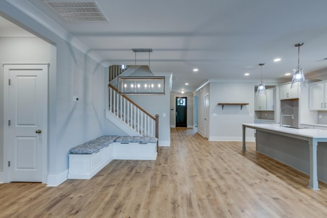 2110 Lequire Ln, Spring Hill, TN 37174 - kitchen featuring white cabinetry, light wood-style flooring, light countertops, ornamental molding, and pendant lighting