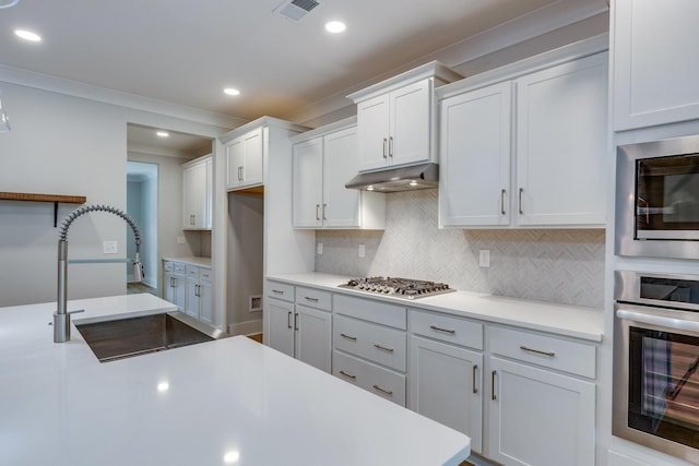 2110 Lequire Ln, Spring Hill, TN 37174 - kitchen with appliances with stainless steel finishes, tasteful backsplash, under cabinet range hood, white cabinetry, and light countertops