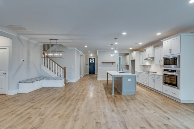 2110 Lequire Ln, Spring Hill, TN 37174 - kitchen featuring stainless steel appliances, under cabinet range hood, light wood finished floors, light countertops, and an island with sink