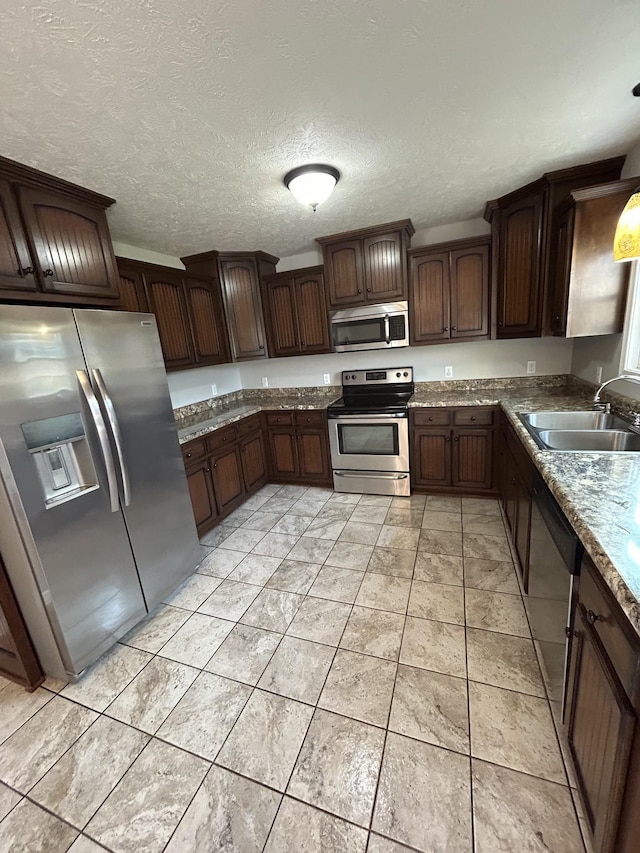 1911 Days Rd, Lafayette, TN 37083 - kitchen featuring stainless steel appliances, dark brown cabinetry, and a textured ceiling