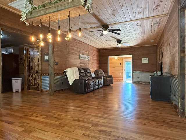 175 State Route 22a S, Jacks Creek, TN 38347 - living area with wooden ceiling, wood finished floors, a ceiling fan, a wood stove, and wood walls