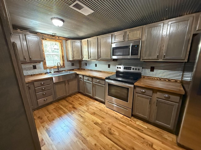 175 State Route 22a S, Jacks Creek, TN 38347 - kitchen with wooden counters, appliances with stainless steel finishes, light wood-style flooring, and decorative backsplash