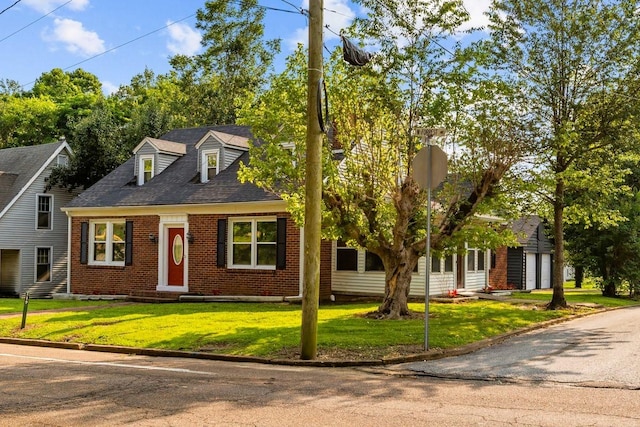 119 N Forrest Ave, Camden, TN 38320 - cape cod home featuring brick siding, a front yard, a garage, and roof with shingles