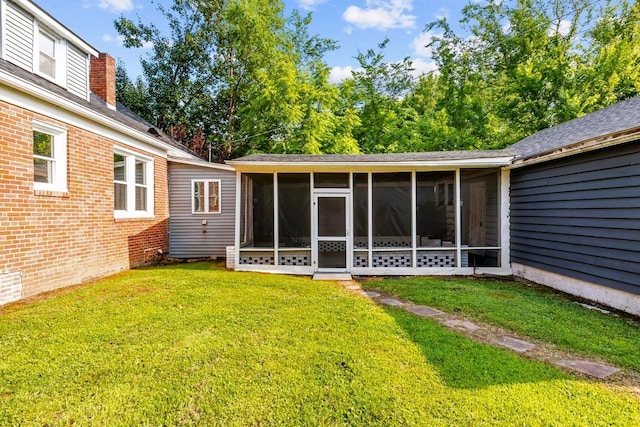 119 N Forrest Ave, Camden, TN 38320 - rear view of property featuring a sunroom, a yard, brick siding, and a chimney