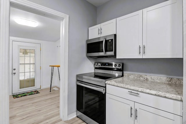 119 N Forrest Ave, Camden, TN 38320 - kitchen featuring appliances with stainless steel finishes, white cabinets, light wood-style flooring, and light stone counters