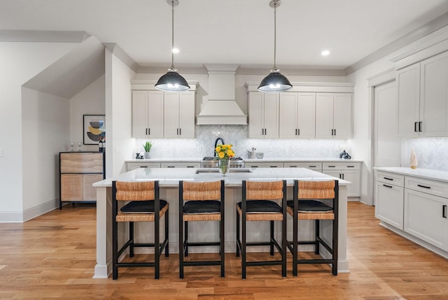 1931 Warfield Dr, Nashville, TN 37215 - kitchen with custom range hood, a kitchen breakfast bar, light countertops, white cabinets, and recessed lighting