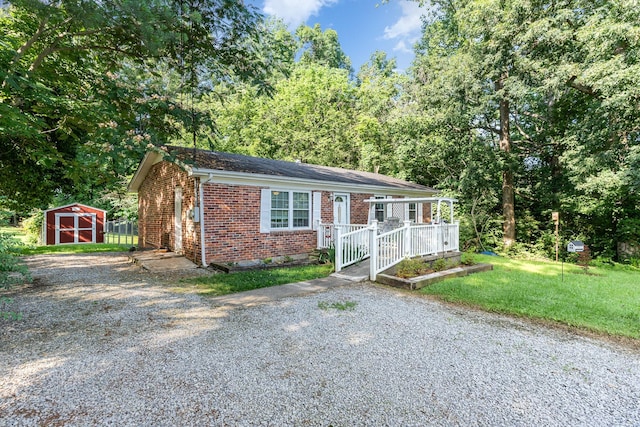 106 Hogin Rd, Dickson, TN 37055 - view of front of home with brick siding, a storage unit, a porch, and a front yard