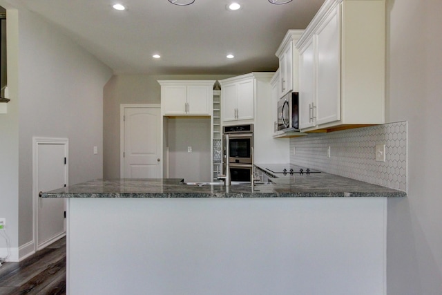 1331 Juniper Pass, Clarksville, TN 37043 - kitchen with appliances with stainless steel finishes, recessed lighting, a peninsula, dark wood-style flooring, and backsplash
