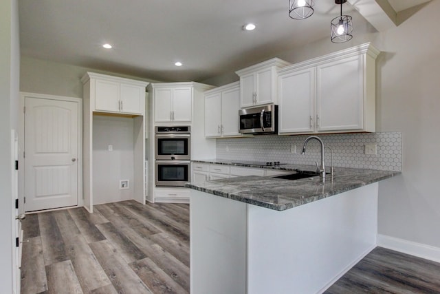 1331 Juniper Pass, Clarksville, TN 37043 - kitchen featuring appliances with stainless steel finishes, dark stone counters, wood finished floors, backsplash, and recessed lighting