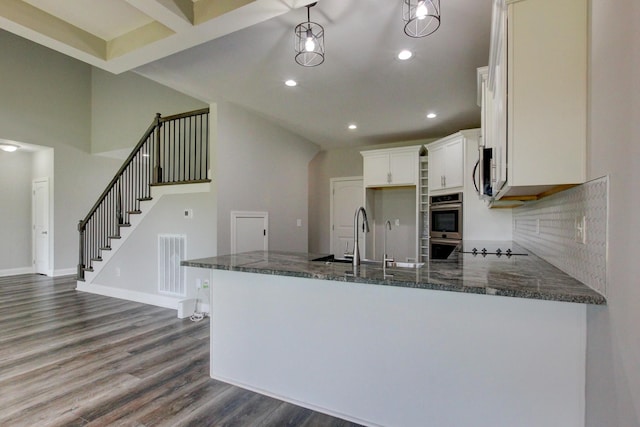 1331 Juniper Pass, Clarksville, TN 37043 - kitchen with dark wood-type flooring, dark stone counters, appliances with stainless steel finishes, a peninsula, and recessed lighting