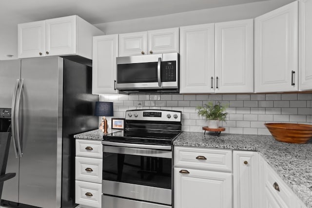 5191 Still House Hollow Rd, Franklin, TN 37064 - kitchen featuring appliances with stainless steel finishes, white cabinets, tasteful backsplash, and light stone counters