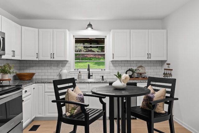 5191 Still House Hollow Rd, Franklin, TN 37064 - kitchen with appliances with stainless steel finishes, white cabinets, tasteful backsplash, and light wood-style floors