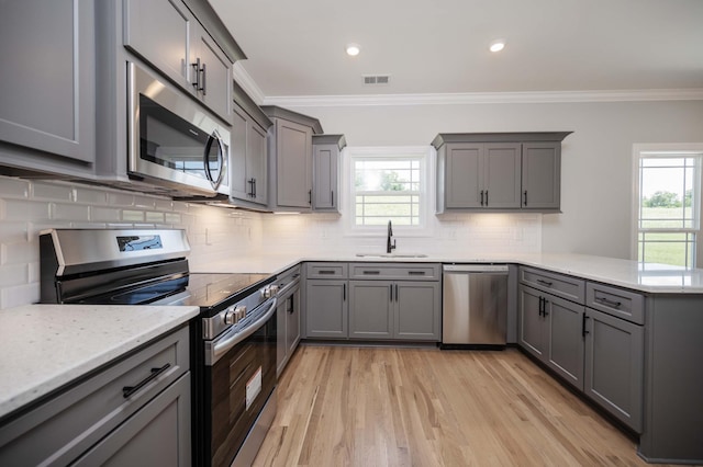 135 Bruce Meadows Dr, Beechgrove, TN 37018 - kitchen featuring stainless steel appliances, gray cabinetry, a peninsula, crown molding, and recessed lighting