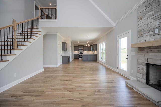 135 Bruce Meadows Dr, Beechgrove, TN 37018 - unfurnished living room featuring ornamental molding, a stone fireplace, a chandelier, stairs, and high vaulted ceiling