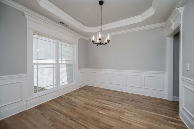 135 Bruce Meadows Dr, Beechgrove, TN 37018 - spare room with a chandelier, a raised ceiling, light wood-style floors, a wainscoted wall, and a decorative wall