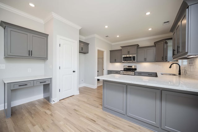135 Bruce Meadows Dr, Beechgrove, TN 37018 - kitchen featuring appliances with stainless steel finishes, gray cabinets, light stone countertops, tasteful backsplash, and light wood finished floors