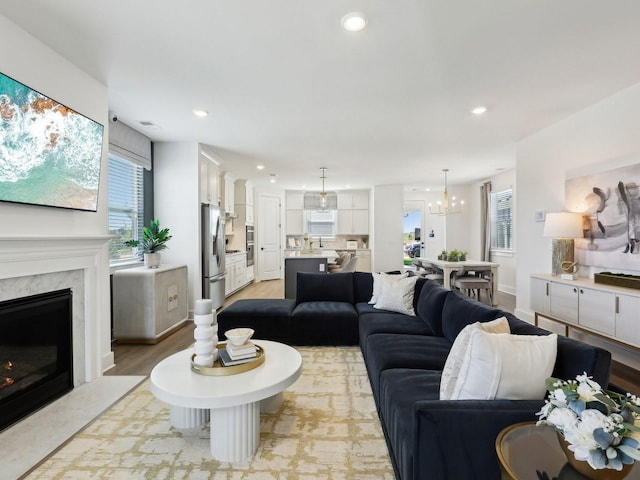 7019 Chardon St, Franklin, TN 37067 - living room with plenty of natural light, a fireplace, a chandelier, recessed lighting, and light wood-style floors