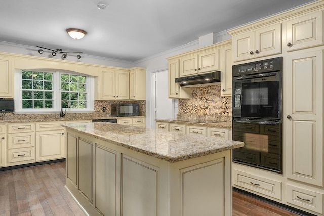 2411 Woolson Rd, Chattanooga, TN 37406 - kitchen featuring cream cabinets, black appliances, a center island, light stone countertops, and decorative backsplash