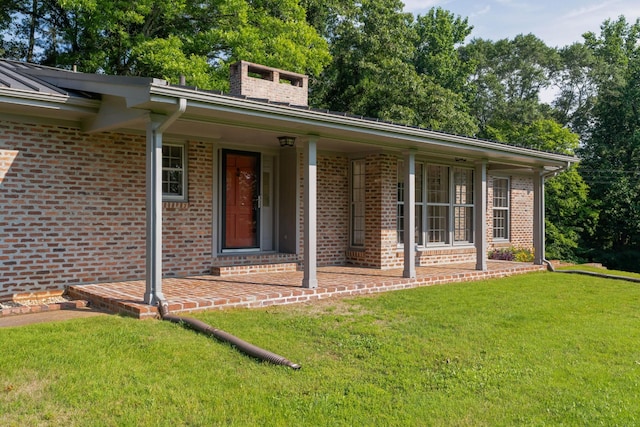 2411 Woolson Rd, Chattanooga, TN 37406 - view of front of house featuring a front yard, brick siding, covered porch, and a chimney