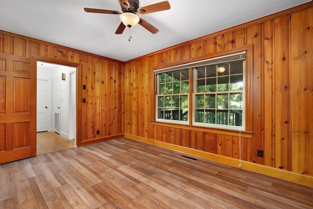 2411 Woolson Rd, Chattanooga, TN 37406 - unfurnished room with light wood-style flooring, a ceiling fan, and wood walls