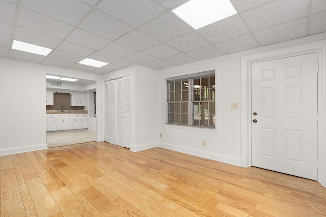 2411 Woolson Rd, Chattanooga, TN 37406 - unfurnished living room featuring light wood-style floors and a paneled ceiling