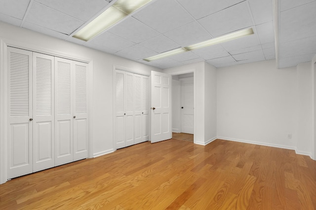2411 Woolson Rd, Chattanooga, TN 37406 - unfurnished bedroom featuring a paneled ceiling, two closets, and light wood finished floors