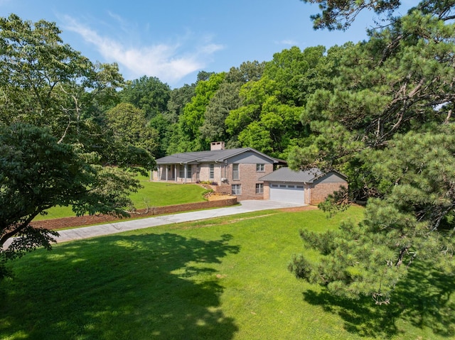 2411 Woolson Rd, Chattanooga, TN 37406 - view of front of home with a forest view, a front lawn, a chimney, concrete driveway, and a garage