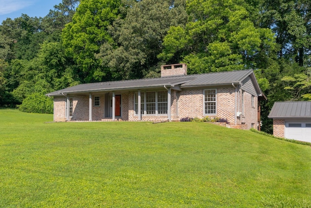 2411 Woolson Rd, Chattanooga, TN 37406 - view of front of house featuring a front lawn, brick siding, a chimney, a garage, and a metal roof
