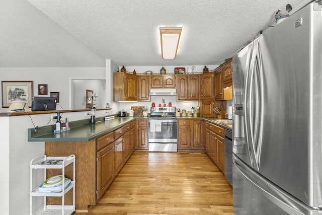 3330 Booker Farm Rd, Mount Pleasant, TN 38474 - kitchen featuring stainless steel appliances, brown cabinets, under cabinet range hood, light wood-type flooring, and a textured ceiling