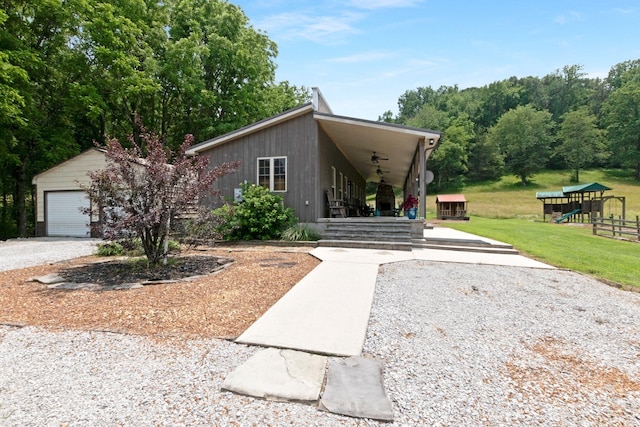 189 Cross Creek Dr, Manchester, TN 37355 - view of front of property featuring ceiling fan, a playground, a front lawn, a detached garage, and an outbuilding