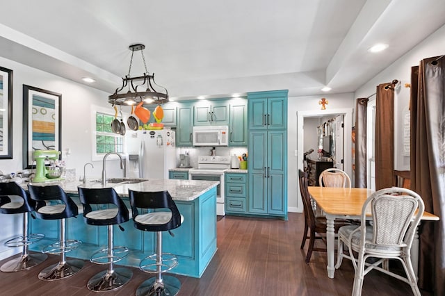 189 Cross Creek Dr, Manchester, TN 37355 - kitchen with white appliances, a peninsula, a breakfast bar, blue cabinetry, and recessed lighting
