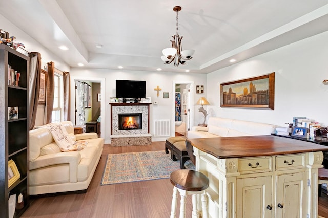 189 Cross Creek Dr, Manchester, TN 37355 - living area featuring a raised ceiling, a lit fireplace, a chandelier, wood finished floors, and recessed lighting