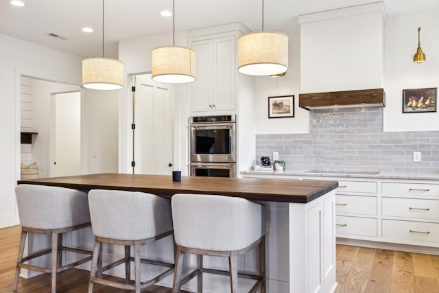 1249 Wilson School Rd, Chapel Hill, TN 37034 - kitchen with stainless steel double oven, wooden counters, light wood finished floors, tasteful backsplash, and white cabinets