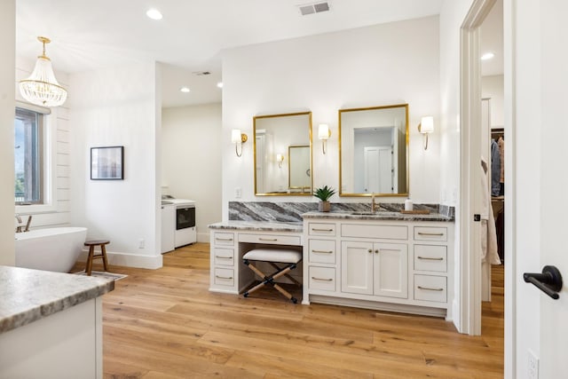 1249 Wilson School Rd, Chapel Hill, TN 37034 - full bathroom featuring vanity, wood finished floors, a freestanding bath, a walk in closet, and a chandelier