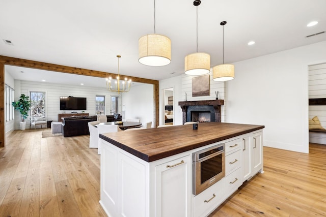 1249 Wilson School Rd, Chapel Hill, TN 37034 - kitchen with butcher block countertops, open floor plan, a lit fireplace, light wood-type flooring, and recessed lighting