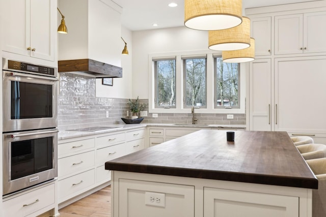 1249 Wilson School Rd, Chapel Hill, TN 37034 - kitchen featuring stainless steel double oven, a center island, decorative backsplash, black electric cooktop, and recessed lighting
