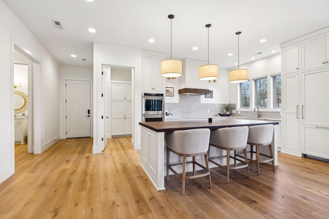 1249 Wilson School Rd, Chapel Hill, TN 37034 - kitchen featuring stainless steel double oven, light wood-style floors, white cabinets, tasteful backsplash, and recessed lighting
