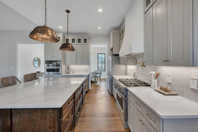 673 Billy Wynn Rd, Dickson, TN 37055 - kitchen featuring appliances with stainless steel finishes, dark wood-style flooring, recessed lighting, a large island, and glass insert cabinets