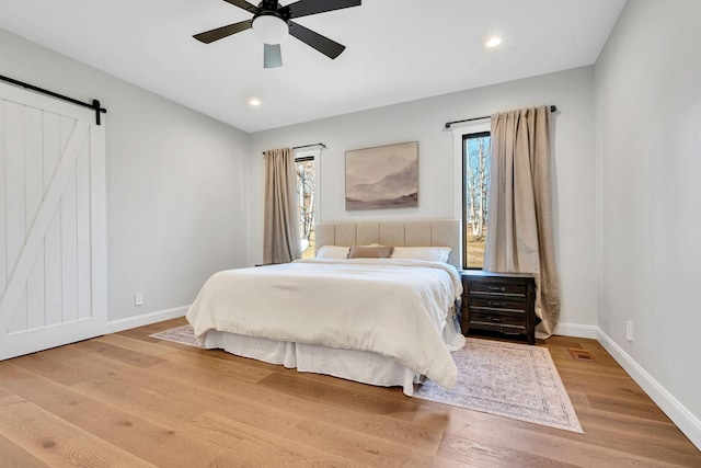 673 Billy Wynn Rd, Dickson, TN 37055 - bedroom featuring a barn door, wood finished floors, recessed lighting, and ceiling fan