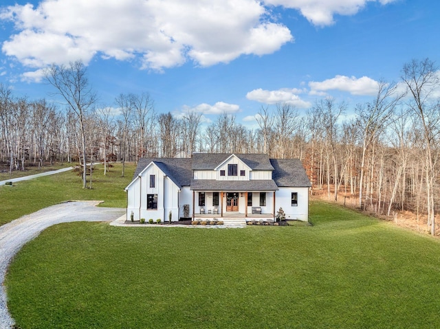 673 Billy Wynn Rd, Dickson, TN 37055 - modern farmhouse style home with covered porch, board and batten siding, a front yard, driveway, and roof with shingles