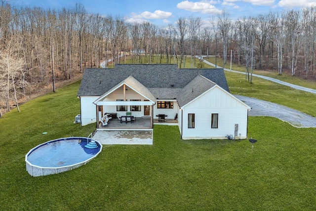673 Billy Wynn Rd, Dickson, TN 37055 - rear view of house featuring board and batten siding, a lawn, a patio, and roof with shingles