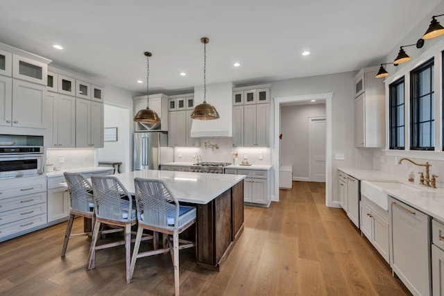 673 Billy Wynn Rd, Dickson, TN 37055 - kitchen featuring appliances with stainless steel finishes, backsplash, recessed lighting, wood finished floors, and a center island