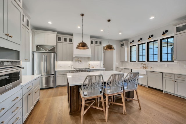 673 Billy Wynn Rd, Dickson, TN 37055 - kitchen featuring stainless steel appliances, decorative backsplash, light wood-type flooring, recessed lighting, and premium range hood