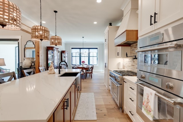 1036 Wilderness Way, Cottontown, TN 37048 - kitchen featuring appliances with stainless steel finishes, custom exhaust hood, light wood-type flooring, recessed lighting, and a center island with sink