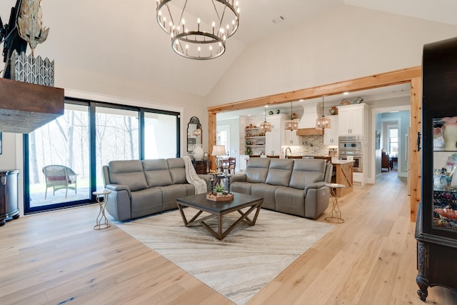 1036 Wilderness Way, Cottontown, TN 37048 - living room featuring high vaulted ceiling, a chandelier, light wood-type flooring, and plenty of natural light